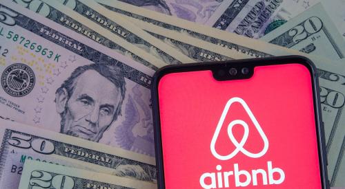 Airbnb app on phone on top of money