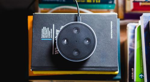 Amazon Echo Dot sitting on pile of books