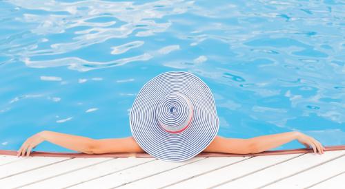 Woman in beach hat on dock in pool