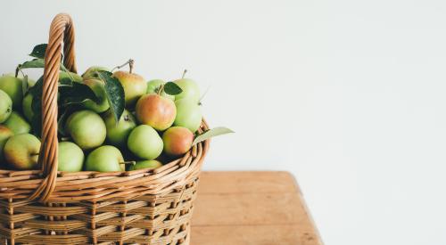 Basket of granny smith apples on a wooden table