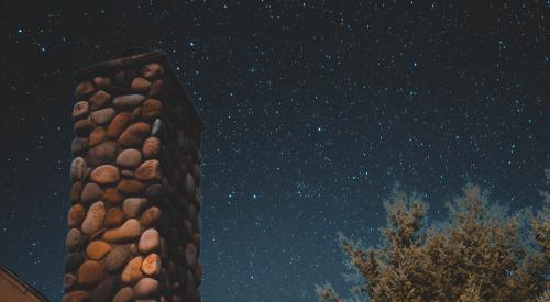 Chimney under night sky with stars