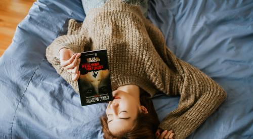 Woman relaxing in bed with a book