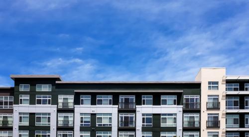 Apartment building backdropped by blue sky