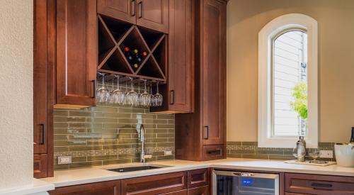 Kitchen prep area with dark wooden cabinets and wine cooler