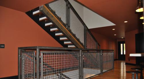 The woven wire mesh of this stair railing was fabricated into panels and installed on site to fit with the home’s rustic-modern aesthetic.