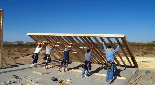 Construction crew raising wall on jobsite