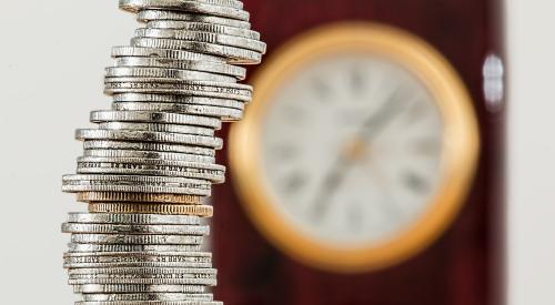 Pile of coins, clock in background
