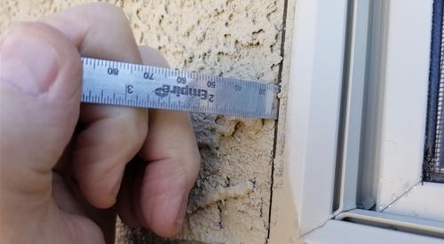 A ruler show the lack of a gap between dissimilar building materials 