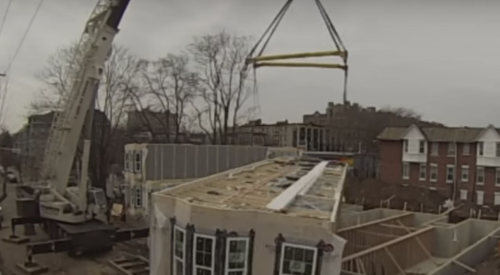 Crane lifting prefabricated apartment building modules into place