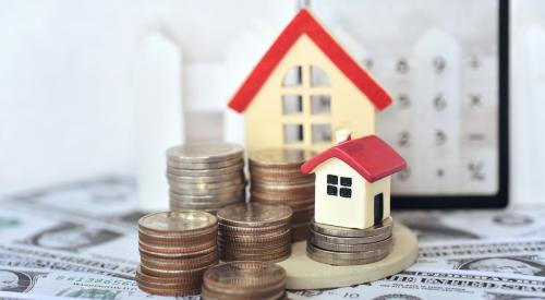Small house model next to cash and stack of coins 