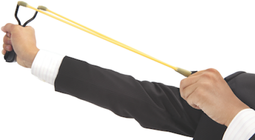 man in business suit aiming slingshot