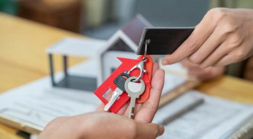 Homebuyer receiving house keys from realtor