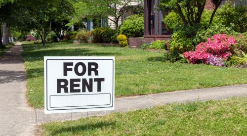 For rent sign in the lawn outside of residential house