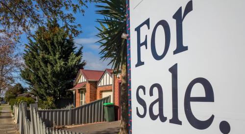 Blue and white for sale sign outside of small residential home