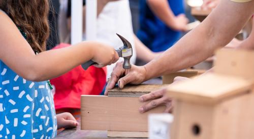 Girl hammering nail in wood box