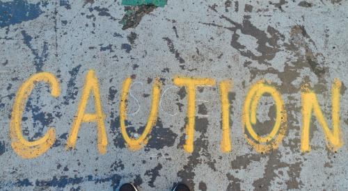 'Caution' written in yellow spray paint