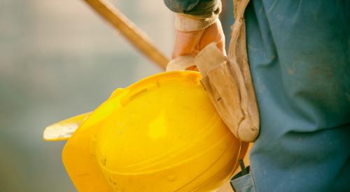 Home builder holding yellow hard hat
