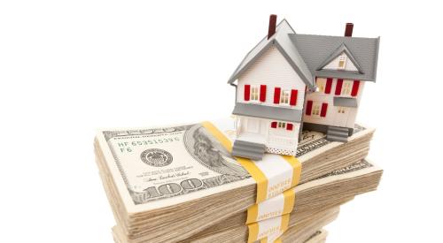 Home model on stack of money