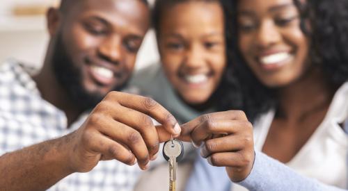 Family holding keys to their home