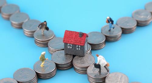 Small figurine homebuyers walking on intersecting stacks of coins toward small house with red roof