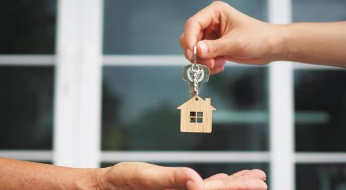 Person placing house keys into open hand