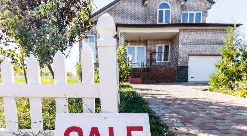 Red and white sale sign outside of residential house