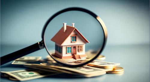 House and cash under magnifying glass