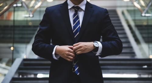 Man in business suit adjusting his tie