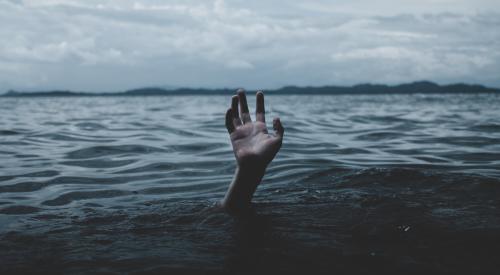 Person underwater raising hand for help