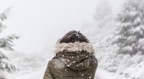 Woman on snowy road | As the Midwest grapples with a frigid polar vortex, a new study analyzes the hows and whys behind cold climate to warm climate home search patterns in the U.S. 