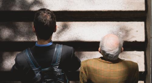 Millennial man with older man walking up steps together