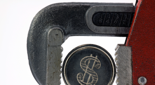 Adjustable wrench squeezing a coin