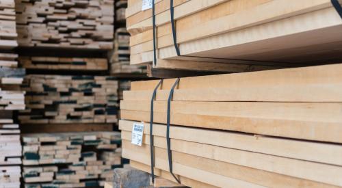 Stacked lumber marked with prices in warehouse