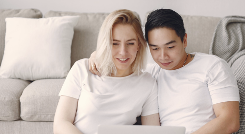man and woman doing home buying research on laptop