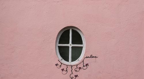 Pink house exterior with window and 'love' written on the wall