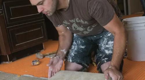 man installs Schluter DITRA membrane for tile floor