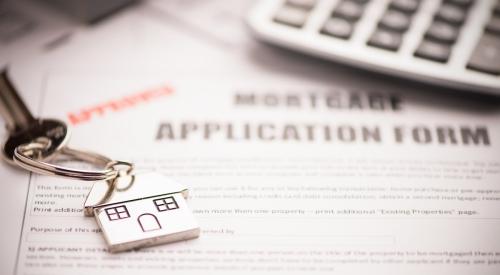 Approved mortgage application beneath calculator and house keys