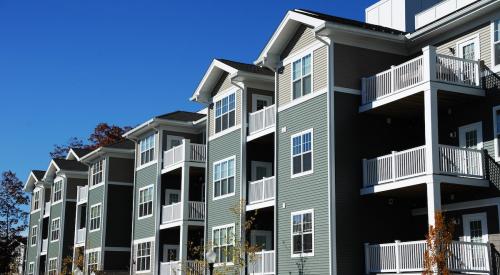 Exterior of gray multifamily apartment building with balconies