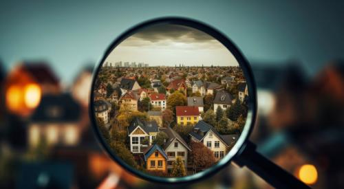 Magnifying glass held up to rendering of houses in neighborhood