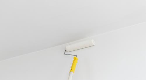 Person with ceiling paint roller