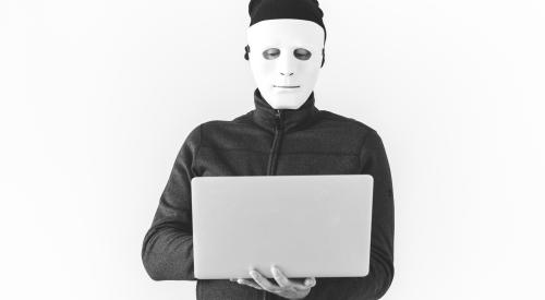 Person in mask using laptop