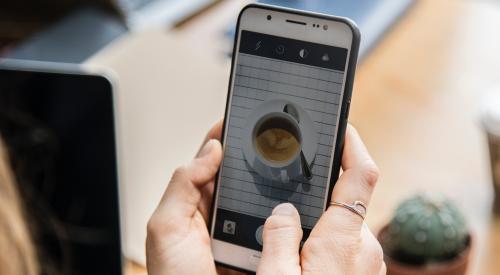 Person taking photo of coffee on smartphone