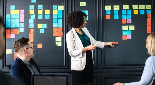 Woman leading meeting with brightly colored post-its