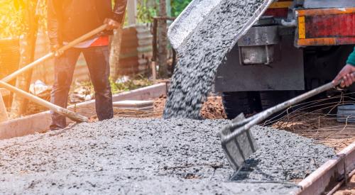 Builders pouring concrete on job site