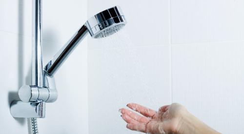 Hand under water flowing from showerhead