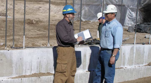site superintendent discusses construction progress with building crew