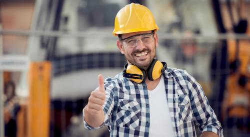 smiling builder on jobsite wearing hardhat