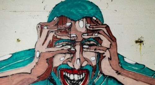 city mural of stressed man holding his head