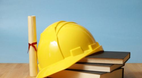 Construction hard hat, books, and diploma on desk