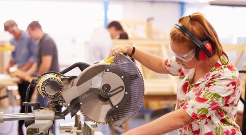 Student using a circular saw in a classroom 